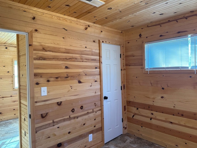 doorway with wood ceiling and wood walls