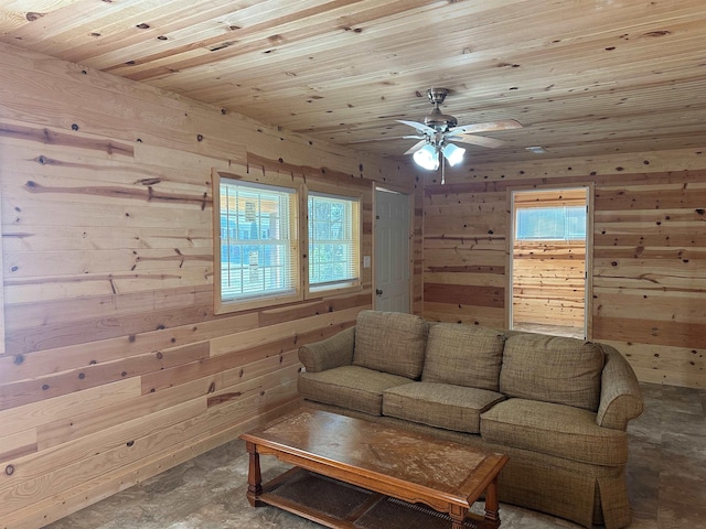 living room with wood ceiling, plenty of natural light, ceiling fan, and wood walls