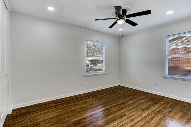 empty room with dark hardwood / wood-style flooring, crown molding, and a healthy amount of sunlight