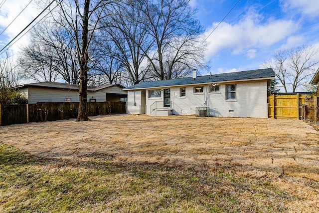 rear view of property featuring cooling unit and a lawn