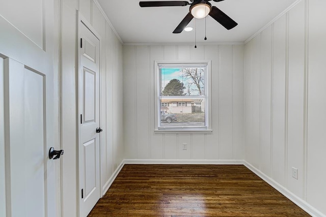 spare room featuring dark wood-type flooring, ceiling fan, and ornamental molding