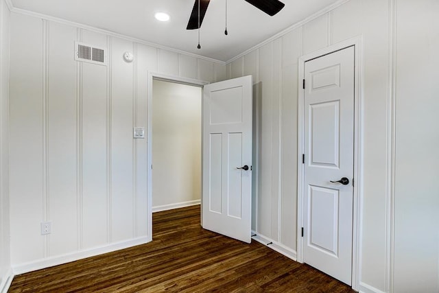 unfurnished bedroom featuring crown molding, dark wood-type flooring, and ceiling fan