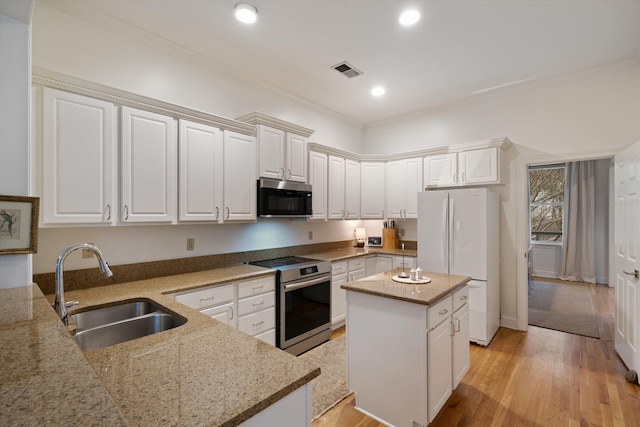 kitchen featuring light stone counters, sink, white cabinetry, and appliances with stainless steel finishes