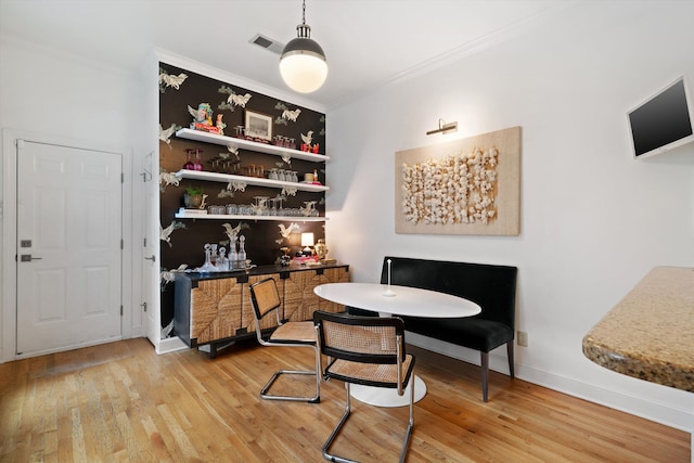 dining room featuring wood-type flooring and crown molding