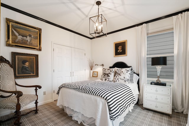 carpeted bedroom with crown molding, an inviting chandelier, and a closet