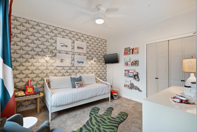 bedroom with crown molding, a closet, ceiling fan, and carpet