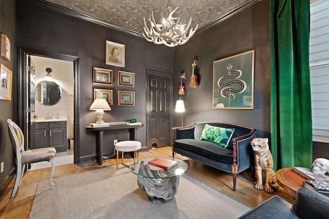 living area featuring crown molding, sink, an inviting chandelier, and light hardwood / wood-style floors