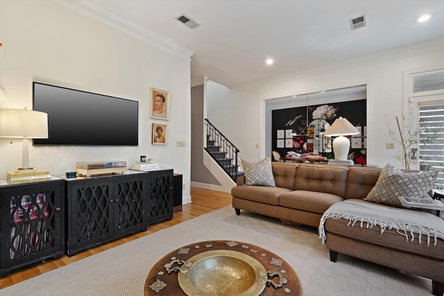 living room with crown molding and light hardwood / wood-style floors