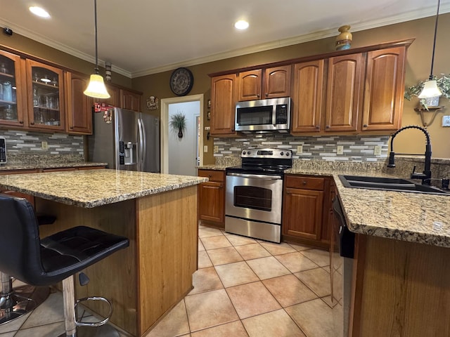 kitchen featuring sink, decorative light fixtures, stainless steel appliances, and light stone countertops