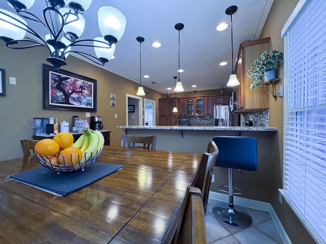 dining space featuring light tile patterned floors and crown molding