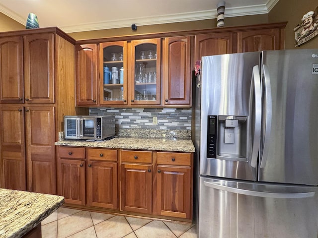 kitchen with crown molding, decorative backsplash, light stone counters, and stainless steel fridge with ice dispenser