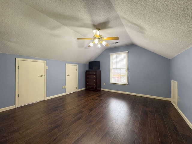 bonus room with vaulted ceiling, a textured ceiling, ceiling fan, and dark hardwood / wood-style flooring