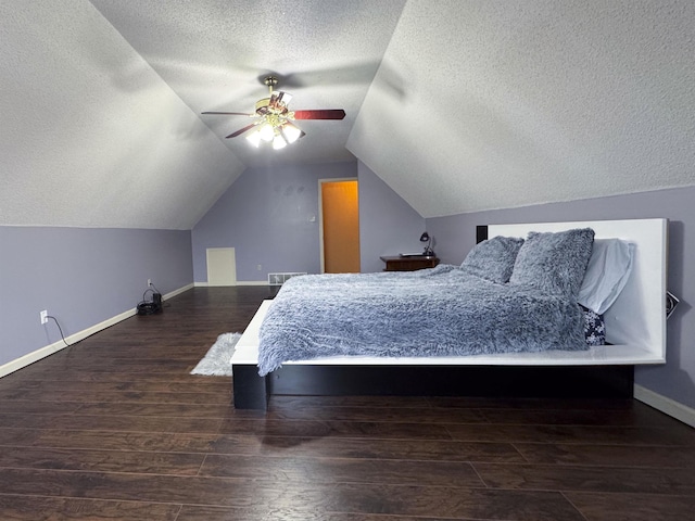 bedroom with dark hardwood / wood-style flooring, ceiling fan, vaulted ceiling, and a textured ceiling