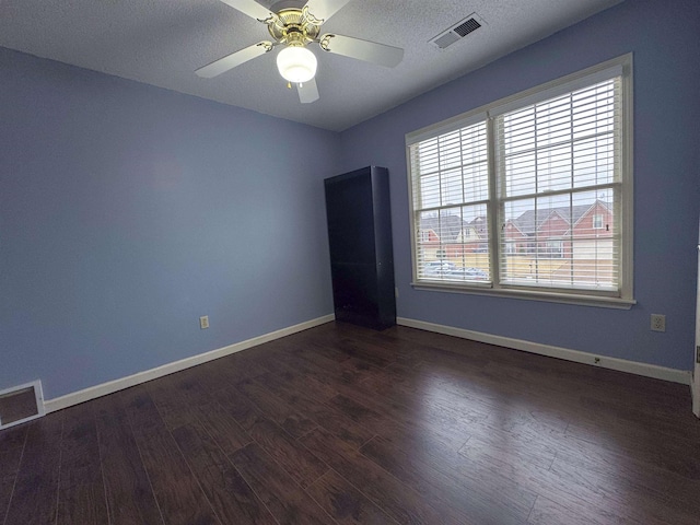 unfurnished room featuring dark wood-type flooring, ceiling fan, and a textured ceiling