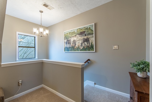 interior space with carpet, an inviting chandelier, and a textured ceiling