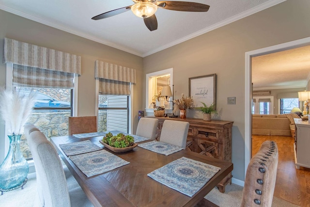 dining room with crown molding, wood-type flooring, and ceiling fan