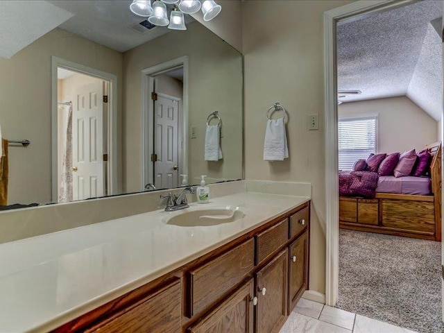 bathroom with tile patterned floors, lofted ceiling, a chandelier, a textured ceiling, and vanity