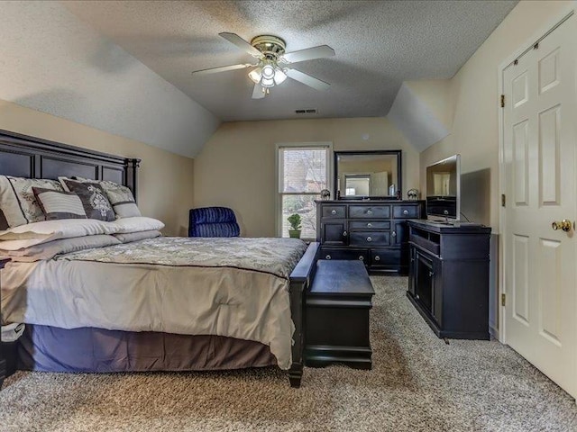 bedroom featuring ceiling fan, vaulted ceiling, a textured ceiling, and dark colored carpet