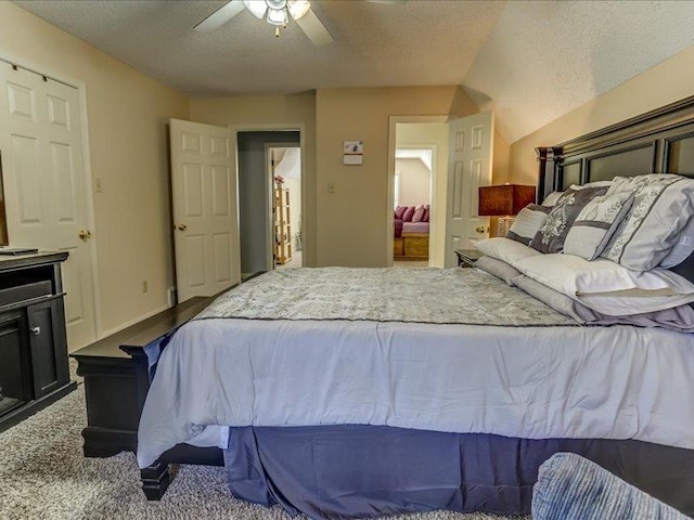 carpeted bedroom featuring ceiling fan and a textured ceiling