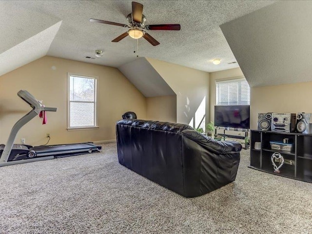 carpeted living room with vaulted ceiling, ceiling fan, and a textured ceiling