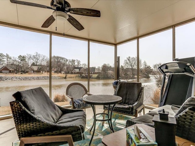 sunroom featuring ceiling fan and a water view