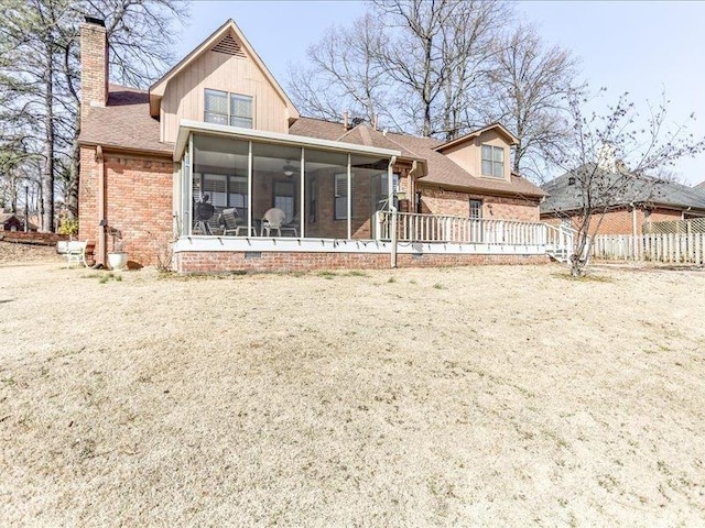 rear view of house with a yard and a sunroom