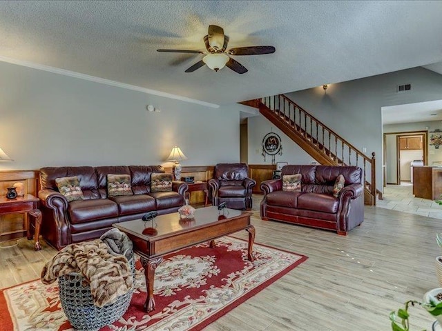 living room with crown molding, a textured ceiling, and light hardwood / wood-style floors