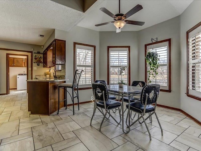 dining room with washer / clothes dryer, sink, a textured ceiling, and ceiling fan