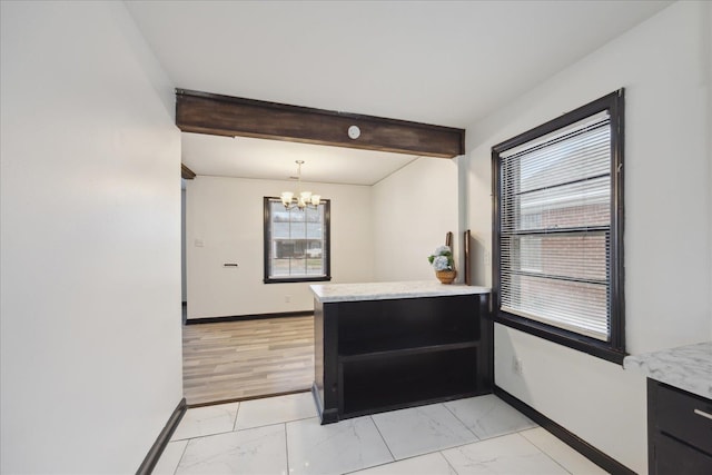 kitchen featuring decorative light fixtures, a chandelier, kitchen peninsula, and beamed ceiling