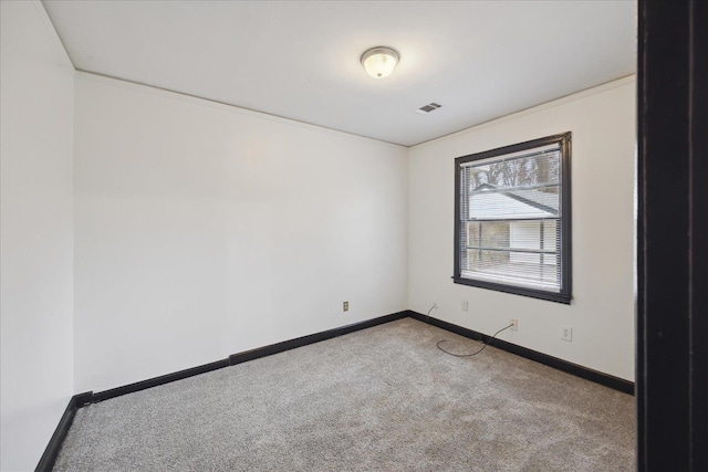 empty room featuring crown molding and light colored carpet