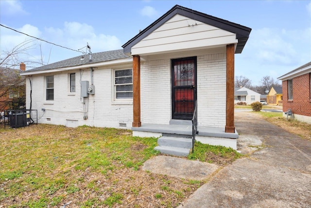 bungalow-style home featuring central AC unit and a front lawn