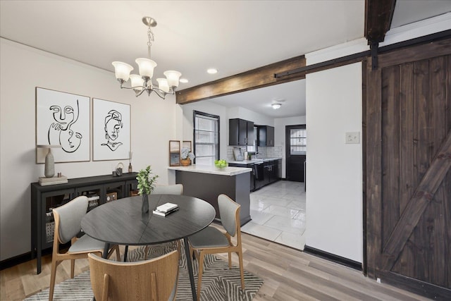 dining area with light hardwood / wood-style floors, a chandelier, beamed ceiling, and a barn door