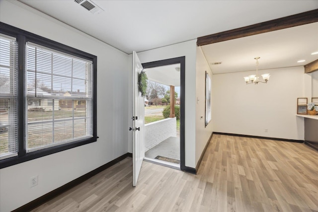 interior space featuring an inviting chandelier and light hardwood / wood-style flooring