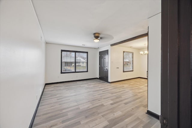 unfurnished room featuring ceiling fan with notable chandelier and light hardwood / wood-style floors