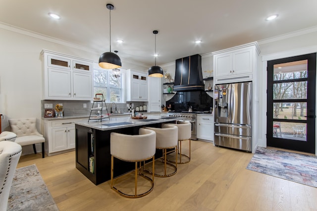 kitchen featuring white cabinetry, pendant lighting, custom exhaust hood, and appliances with stainless steel finishes