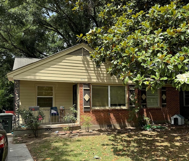 bungalow with cooling unit and a porch