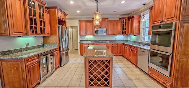 kitchen with sink, decorative light fixtures, a center island, appliances with stainless steel finishes, and beverage cooler