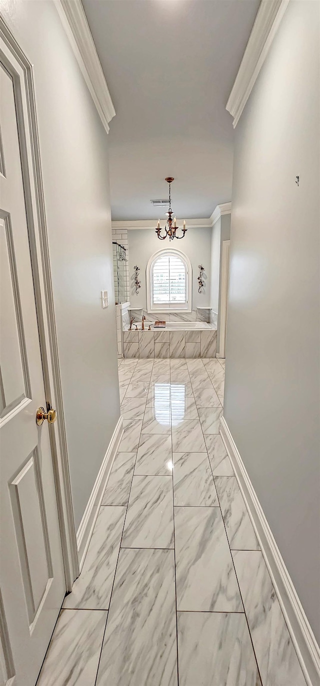 corridor featuring crown molding and a notable chandelier