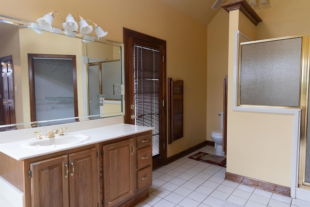 bathroom featuring a shower with door, vanity, tile patterned floors, and toilet