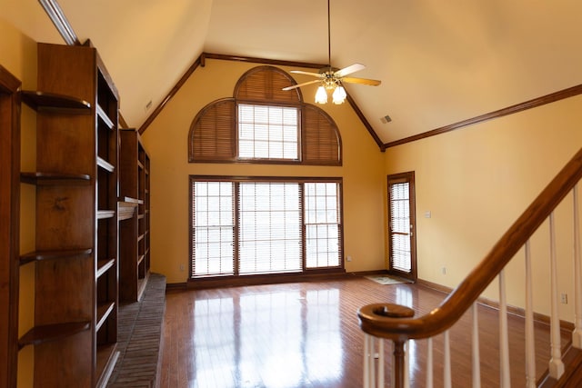 interior space featuring hardwood / wood-style flooring, ceiling fan, ornamental molding, and high vaulted ceiling