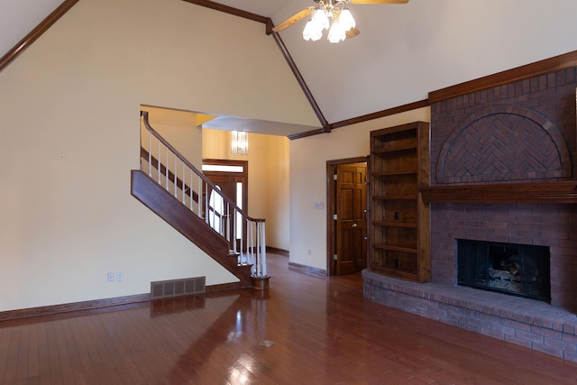 unfurnished living room with hardwood / wood-style floors, a fireplace, high vaulted ceiling, ceiling fan, and crown molding