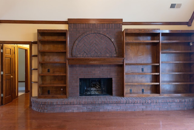 unfurnished living room featuring hardwood / wood-style floors and a brick fireplace