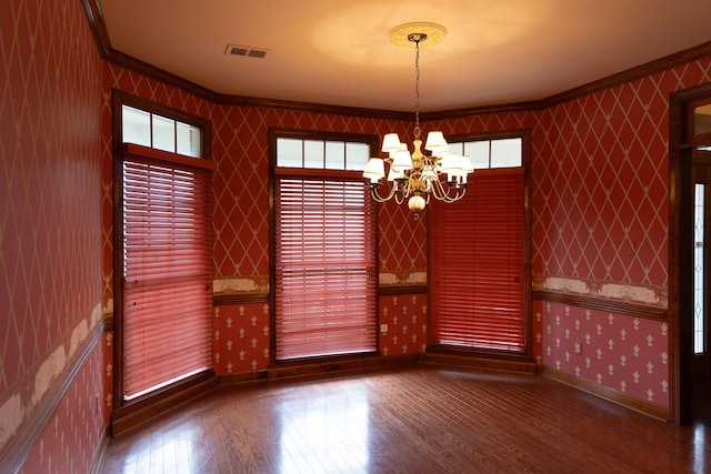 unfurnished dining area featuring crown molding, wood-type flooring, and plenty of natural light