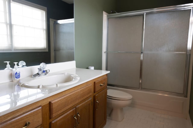 full bathroom with vanity, tile patterned floors, enclosed tub / shower combo, and toilet