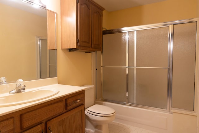 full bathroom featuring vanity, combined bath / shower with glass door, tile patterned floors, and toilet