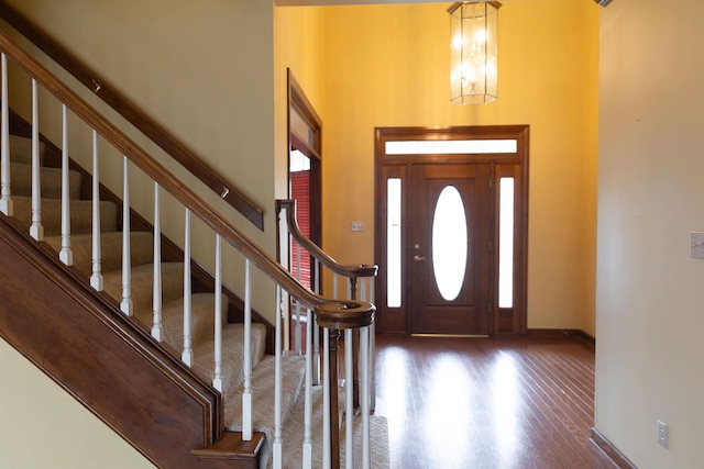 entrance foyer featuring dark hardwood / wood-style flooring, a chandelier, and a high ceiling