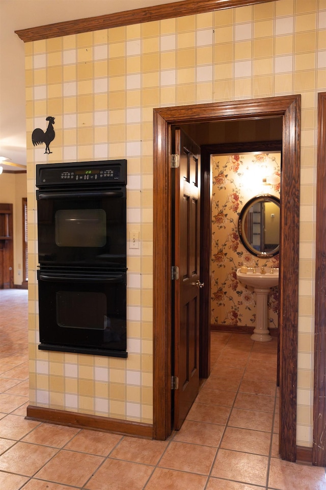 kitchen with black double oven and light tile patterned flooring