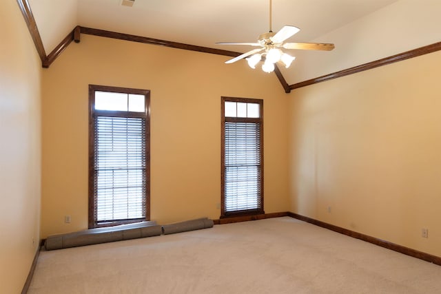 empty room featuring ceiling fan, a healthy amount of sunlight, ornamental molding, and carpet flooring