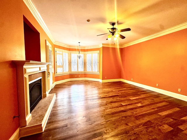 unfurnished living room featuring dark wood-type flooring, ornamental molding, a premium fireplace, and ceiling fan with notable chandelier