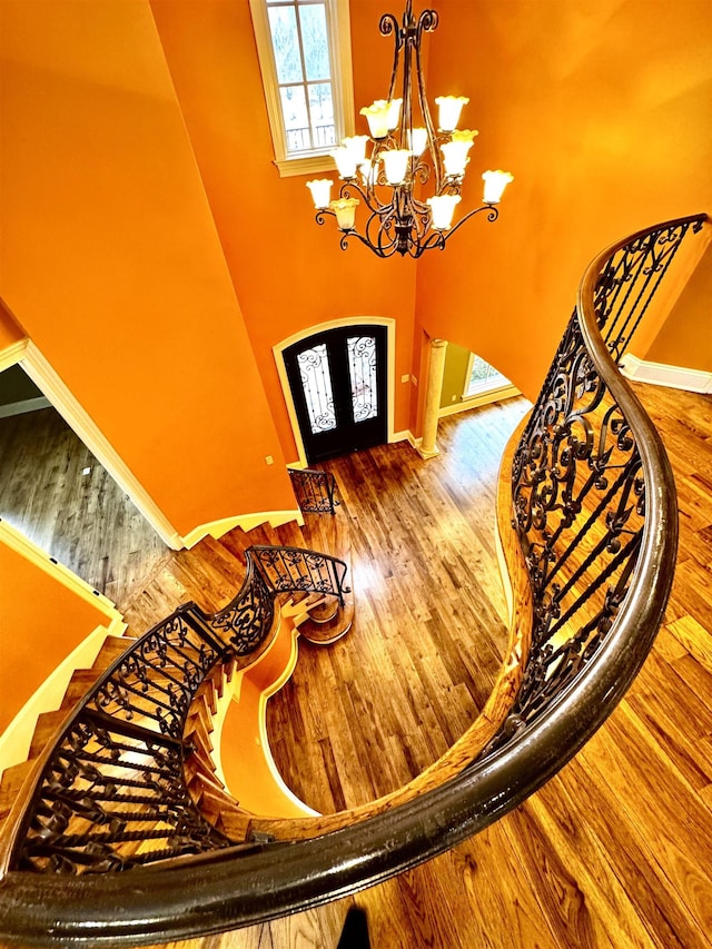 stairs featuring hardwood / wood-style flooring and a notable chandelier